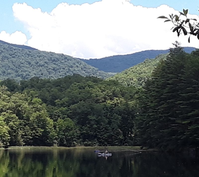 Kayaker exploring finger of Lake Santeetlah in the mountains.